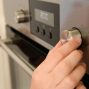 tangan sedang mengatur suhu oven